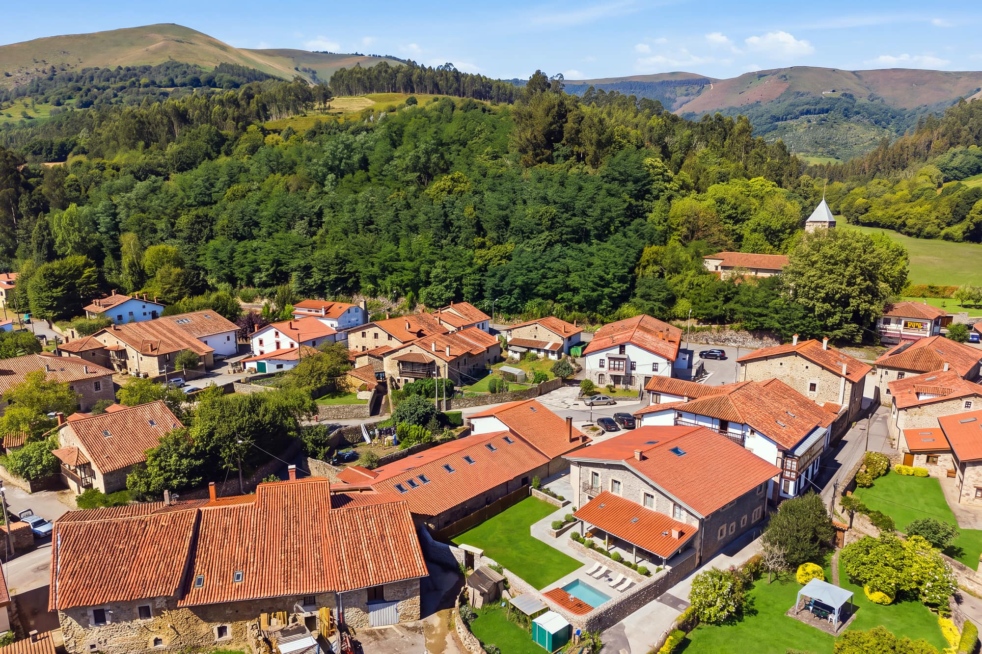 Vista aérea del pueblo de Valle de Cabuérniga rodeado de bosque y montañas